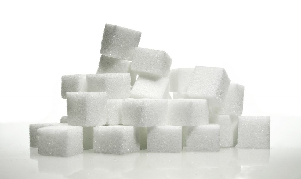 A pile of white sugar cubes on a white background