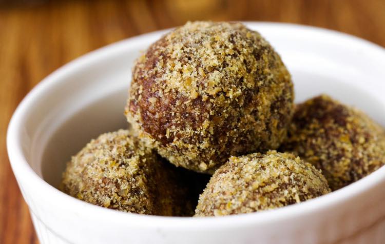 Post-workout protein power balls coated in ground almond, in a white dish