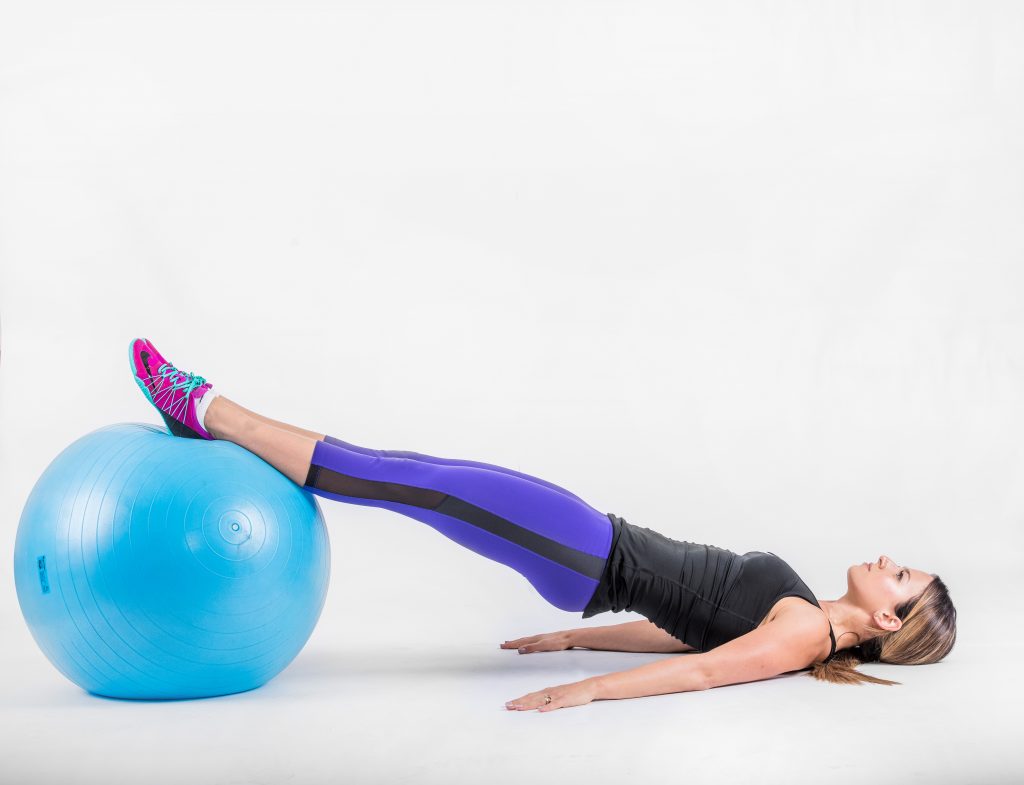 Hips lifted with the body in one line from shoulders to heels on the ball