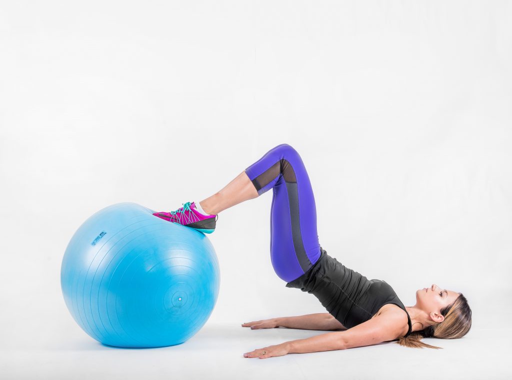 Knees drawn in towards the hips with the feet flat on top of the ball