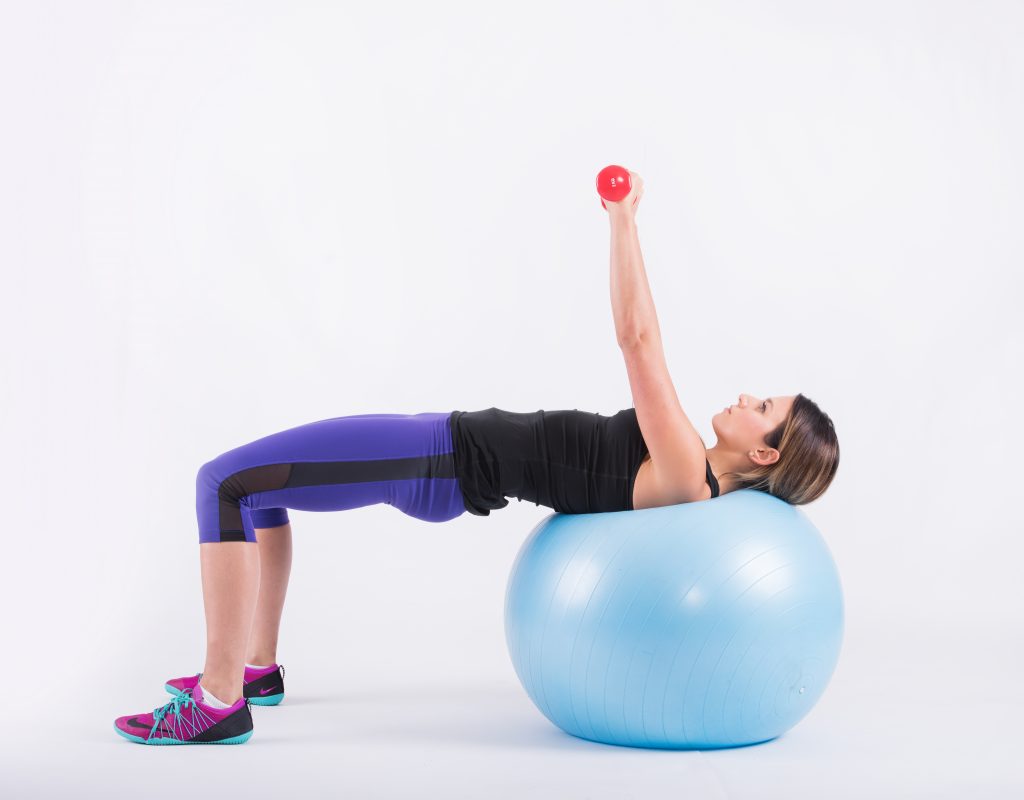 Dumbbells pushed straight up from the chest with the shoulder blades on the ball