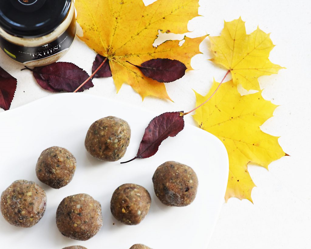 Close-up of nut and sesame power balls on a white board with autumn leaves