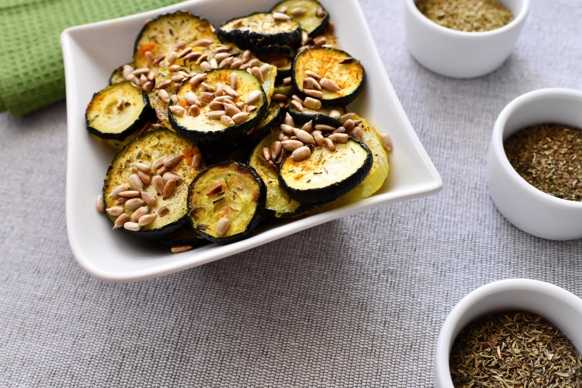 Roasted kohlrabi and zucchini slices sprinkled with sunflower seeds and herbs
