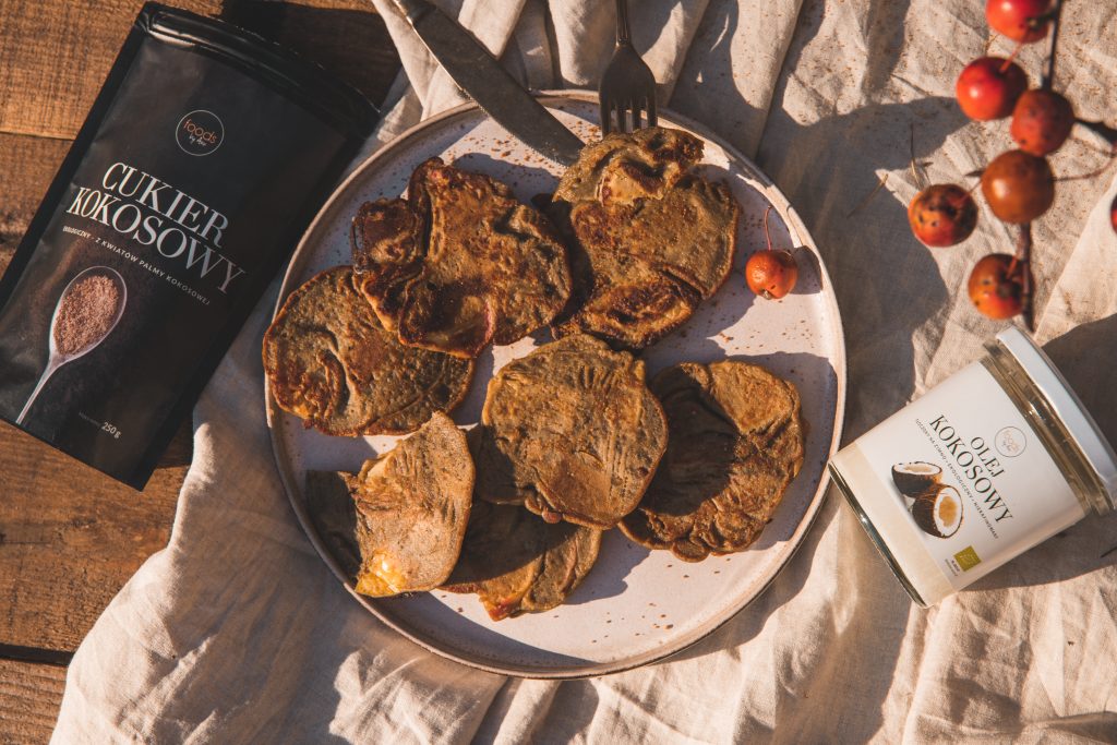 Apple crumpets on a plate with a pack of coconut sugar and a jar, on a linen cloth with crab apples